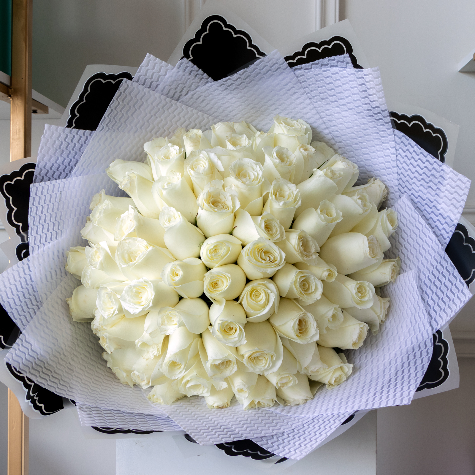 Ramo de 75 rosas blancas premium envuelto en papel coreano y liston