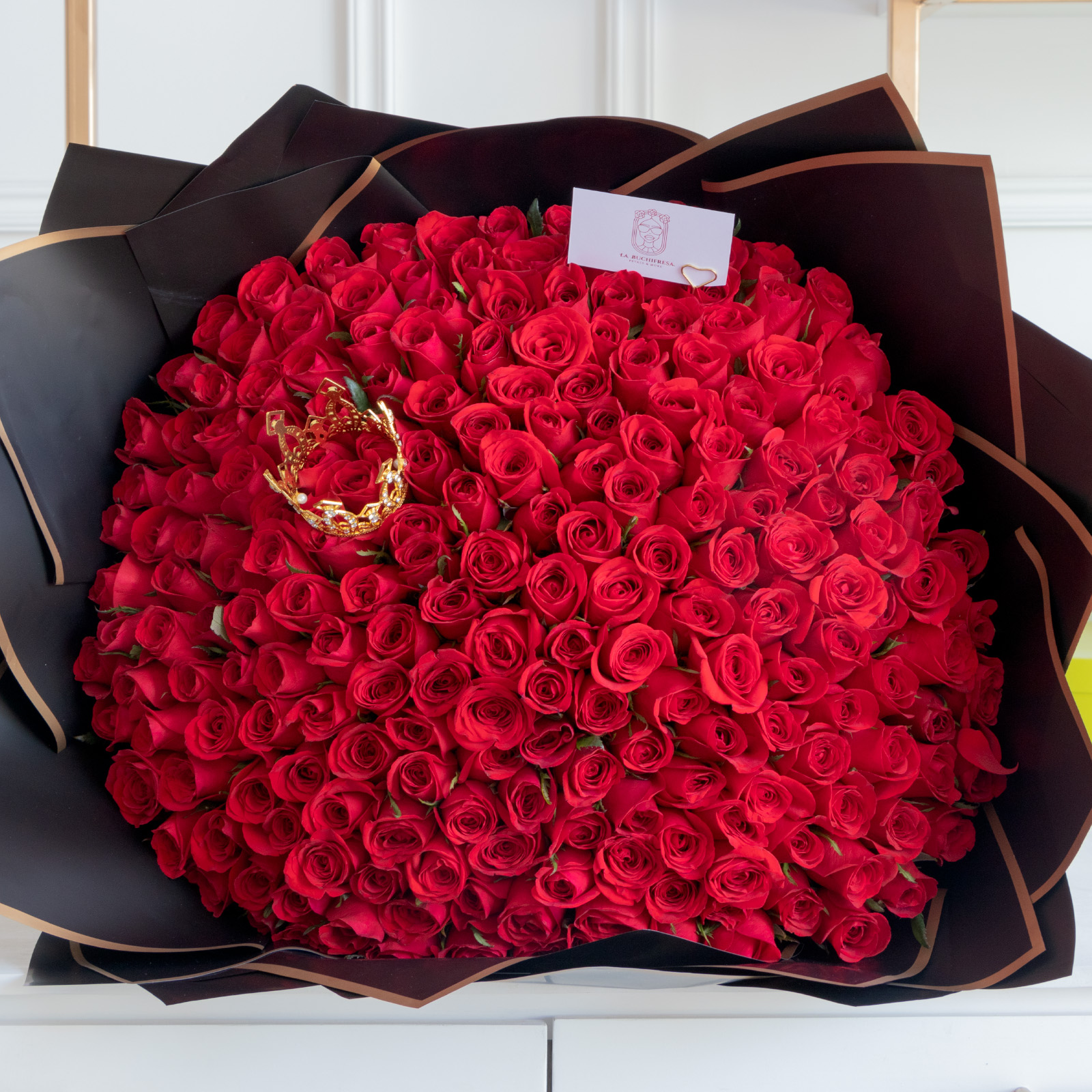 Ramo de 300 rosas rojas premium con una corona encima envuelto en papel coreano y liston