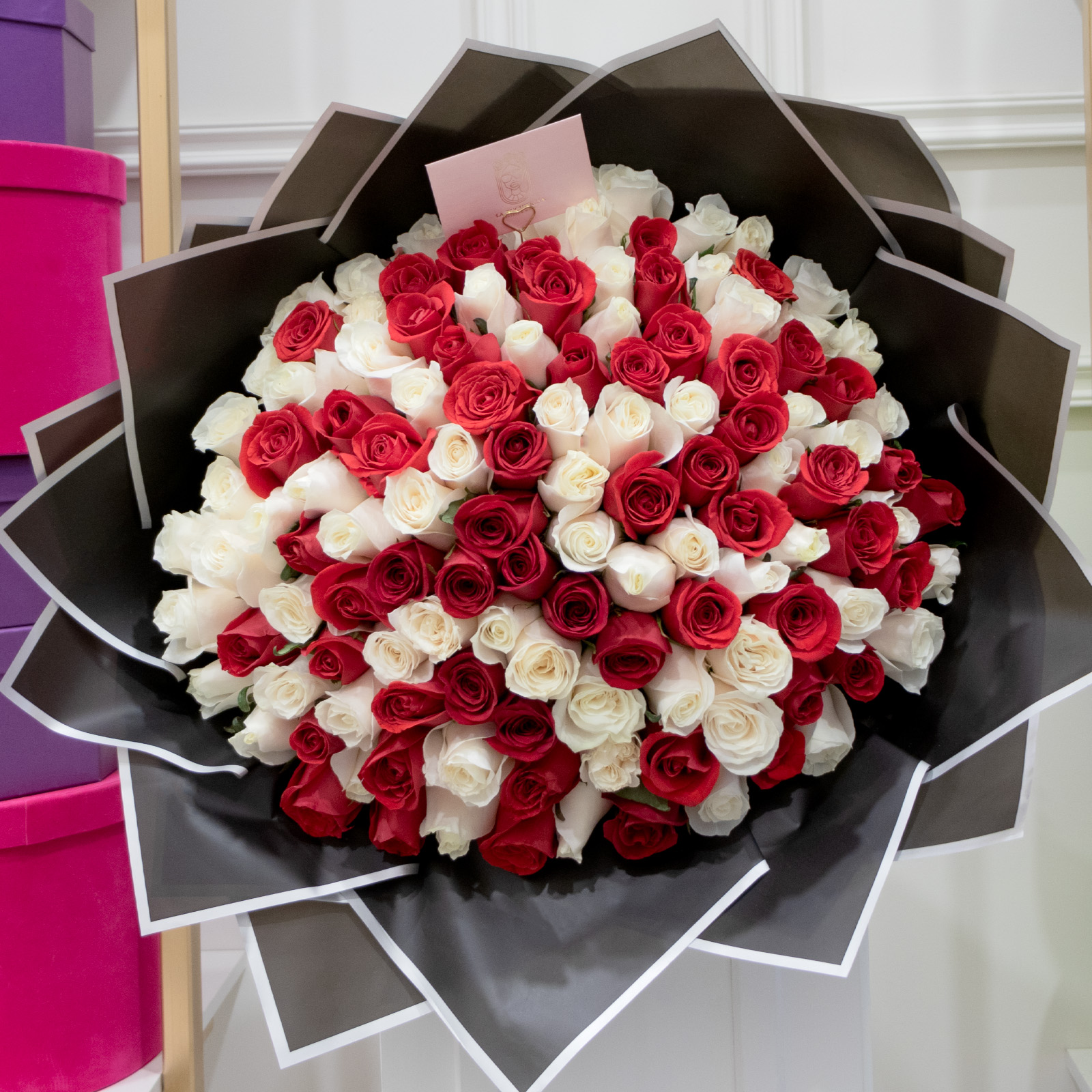 Ramo de 100 rosas rojas y blancas premium envuelto en papel coreano y liston