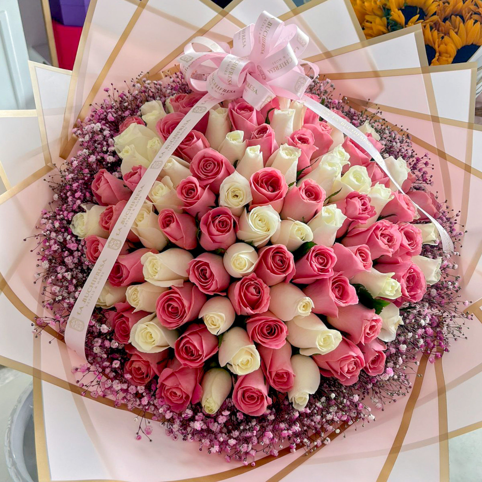 Ramo de 100 rosas blancas y rositas premium con gypso rosa alrededor envuelto en papel coreano y liston