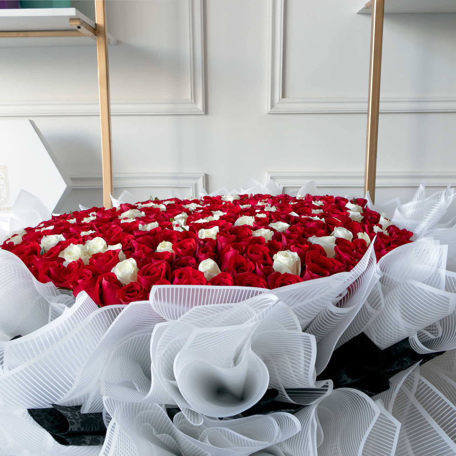 Arreglo en forma de jardin con 600 rosas rojas y blancas premium al ras envuelto en papel coreano