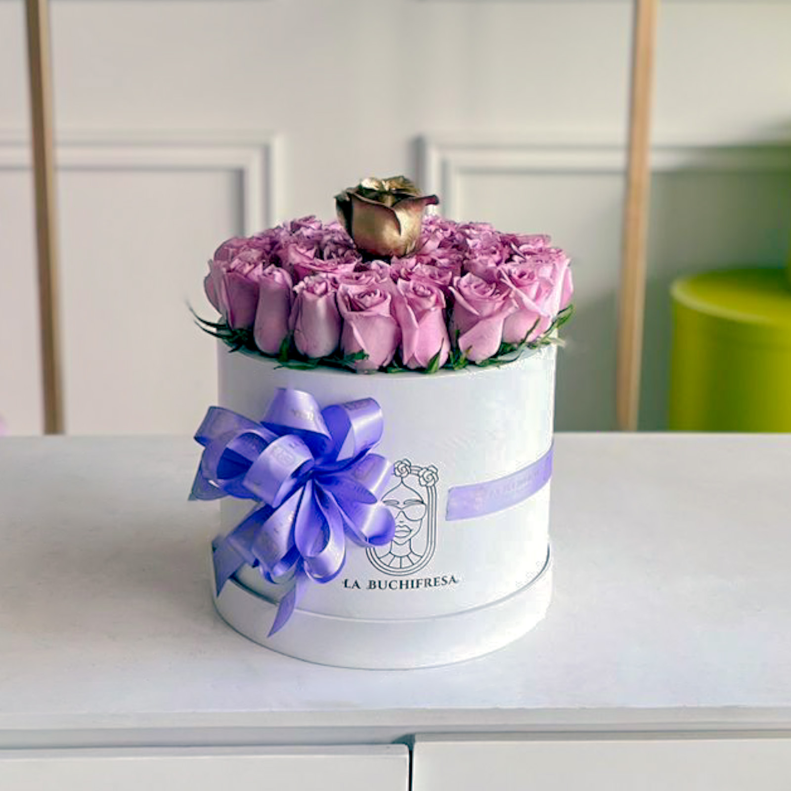 arreglo de 44 rosas lila y una golden rose premium al ras sobre white round small box con liston