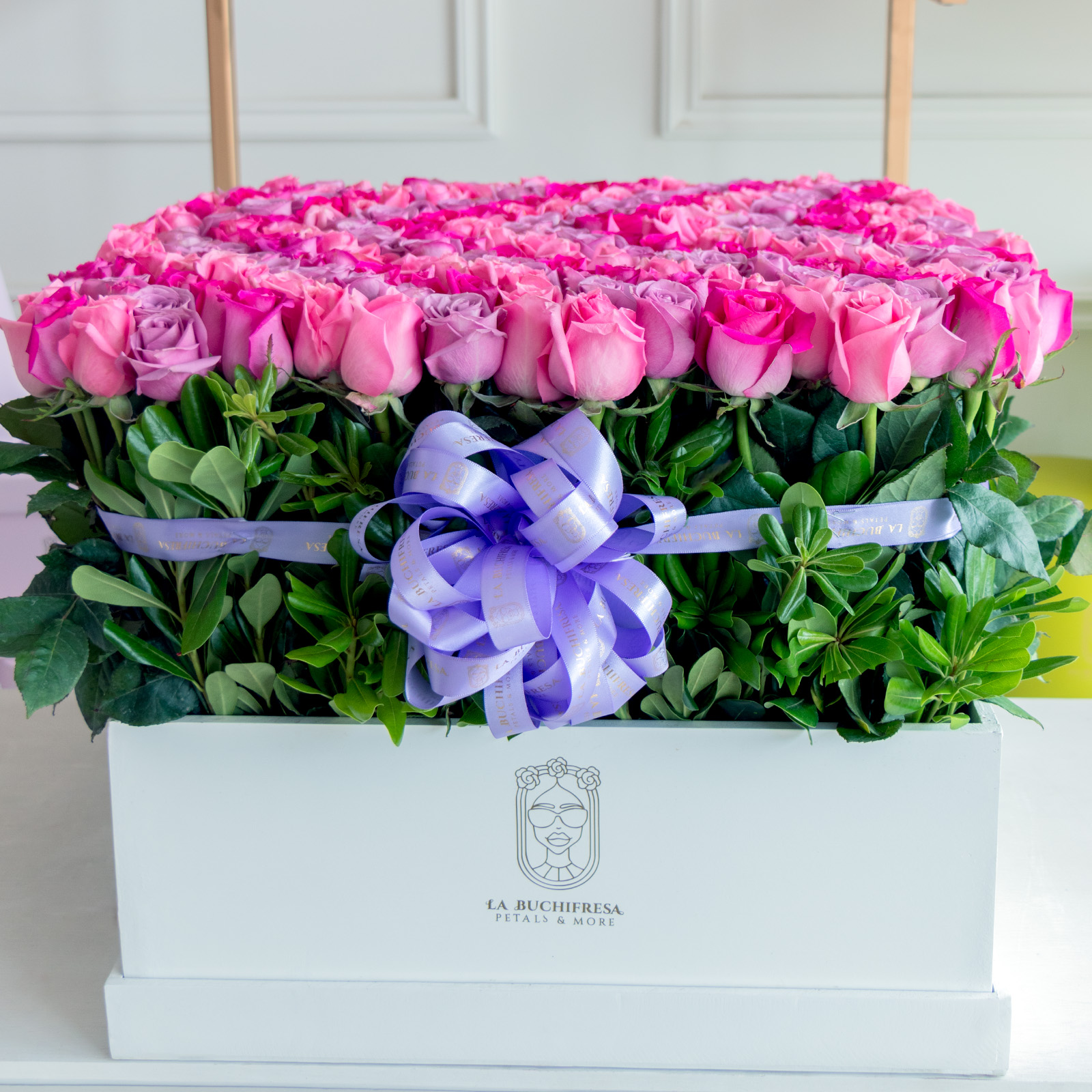 Arreglo en forma de jardin de 300 rosas violetas y fucsia premium sobre square white box con liston