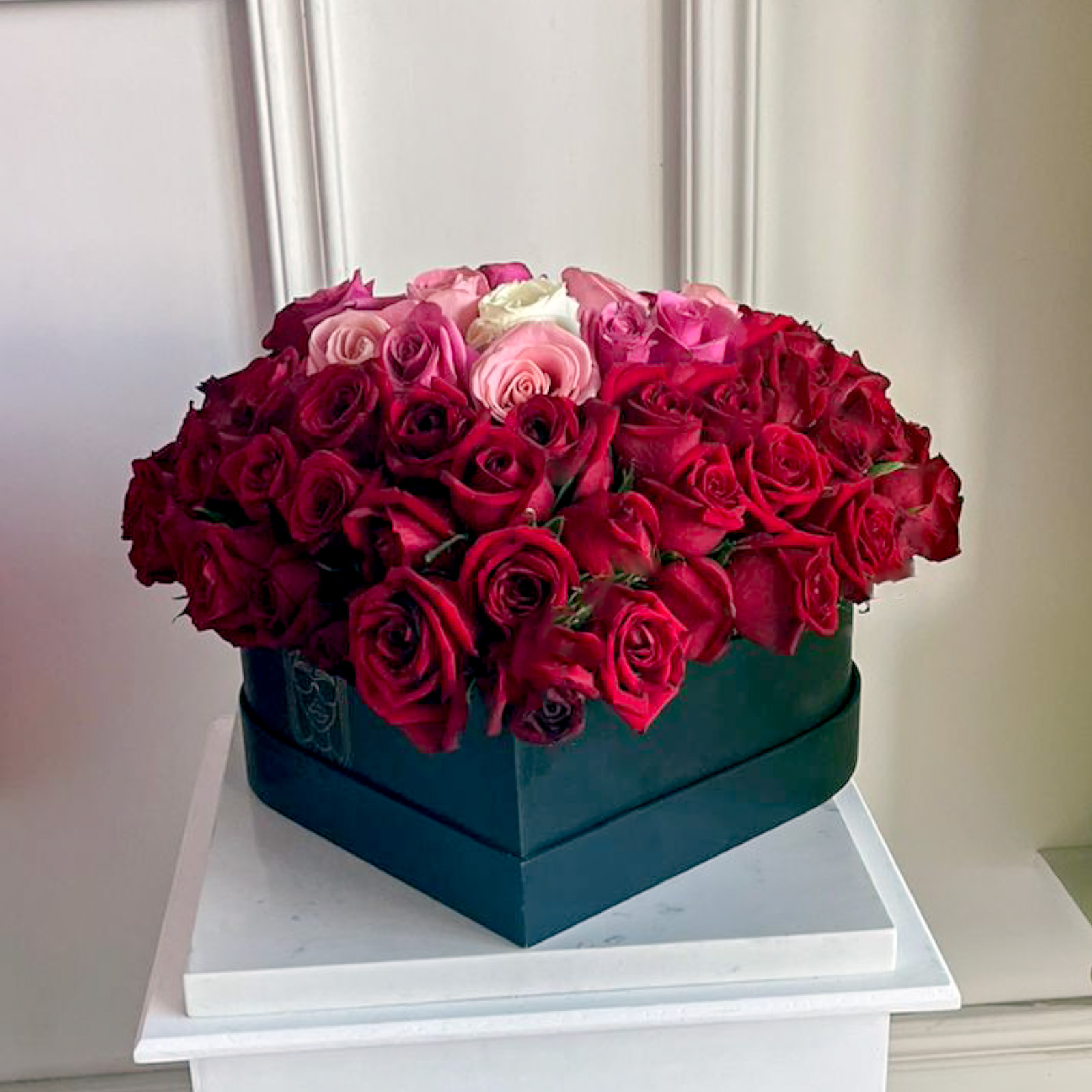 Arreglo en forma de corazon levantado de 100 rosas rojas y tonos pastel premium en base de corazon negra