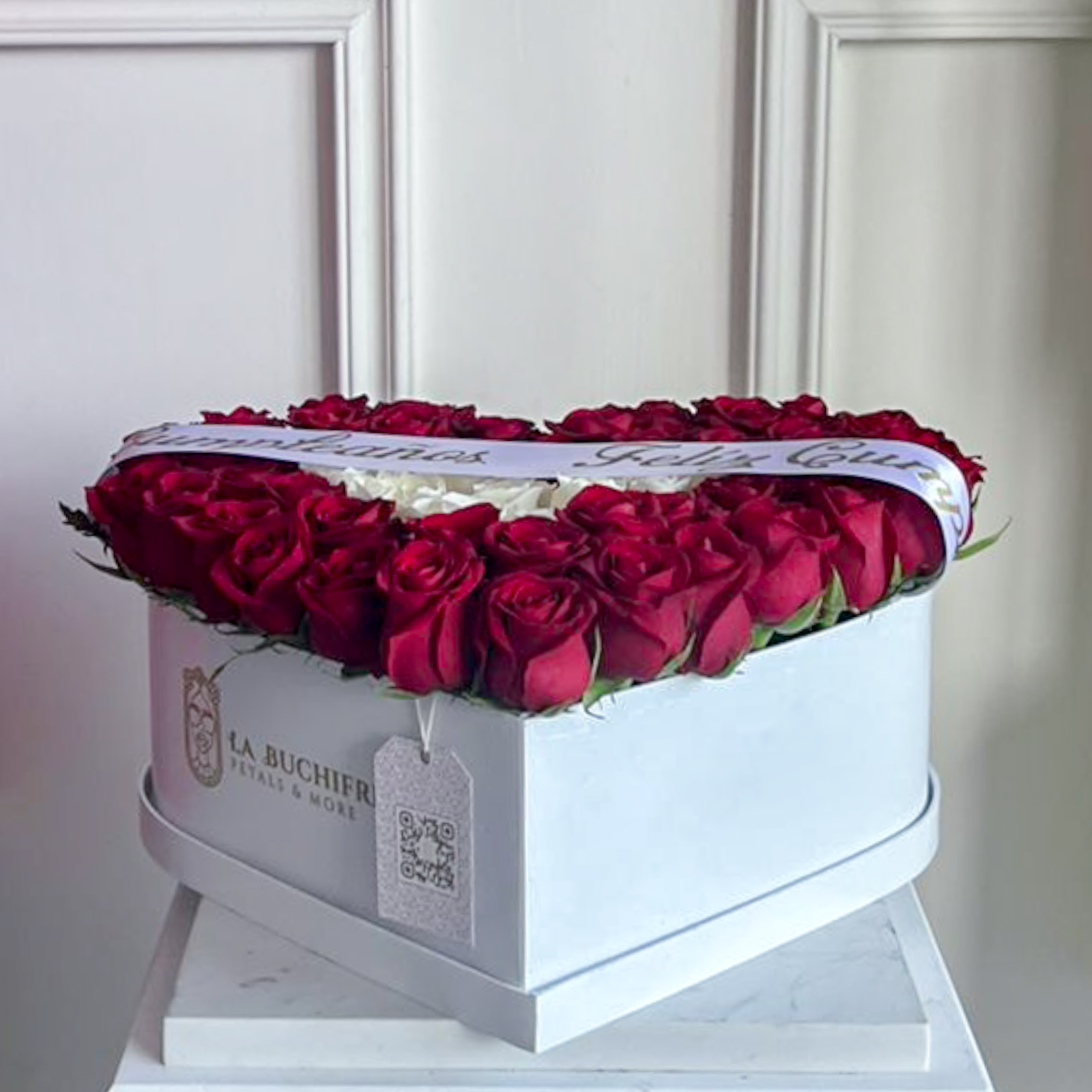 Arreglo de 65 roas rojas y blancas en caja de corazon blanca con liston de feliz cumpleaños encima