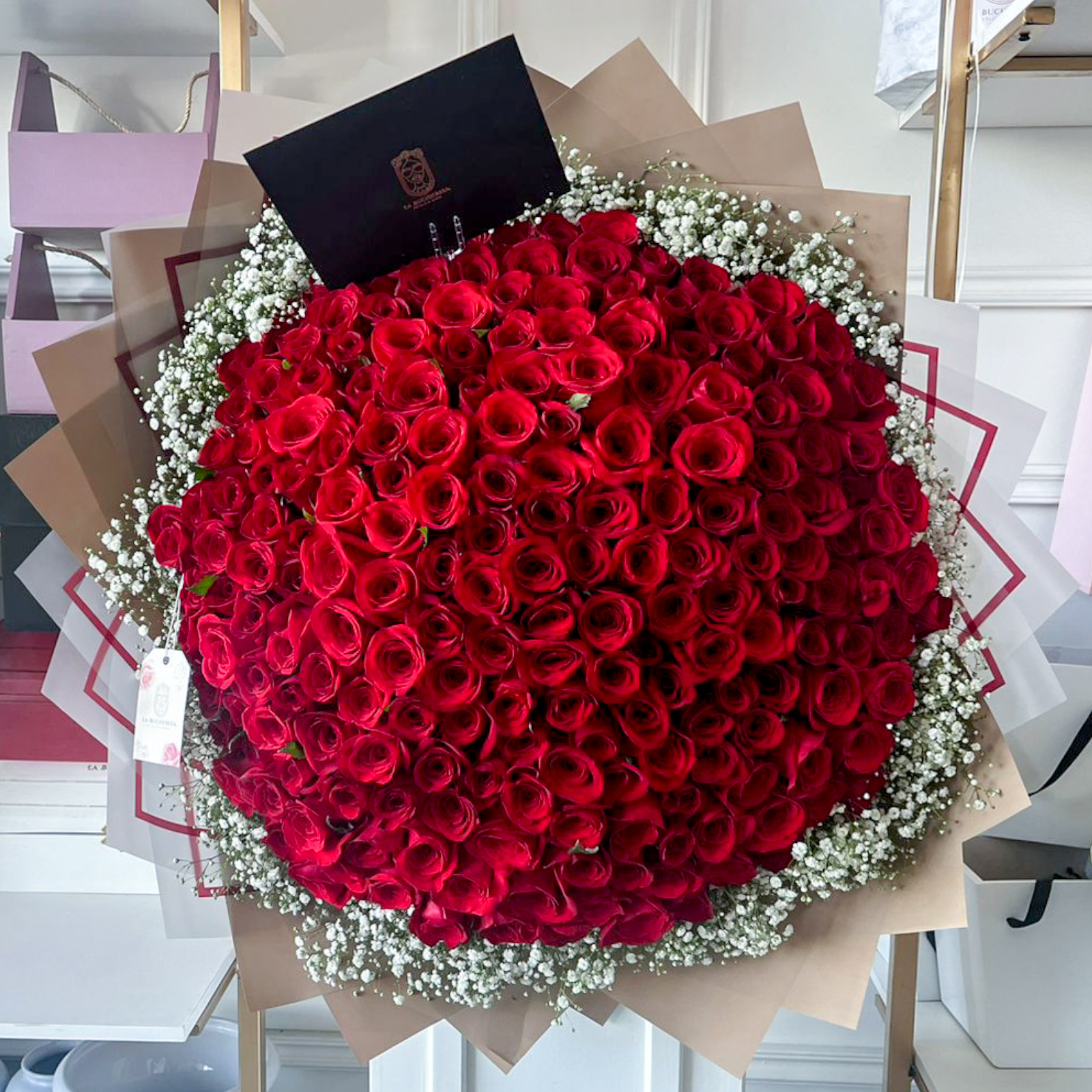 Ramo de 200 rosas rojas premium con gypsofilia blanca alrededor envuelto en papel coreano y liston