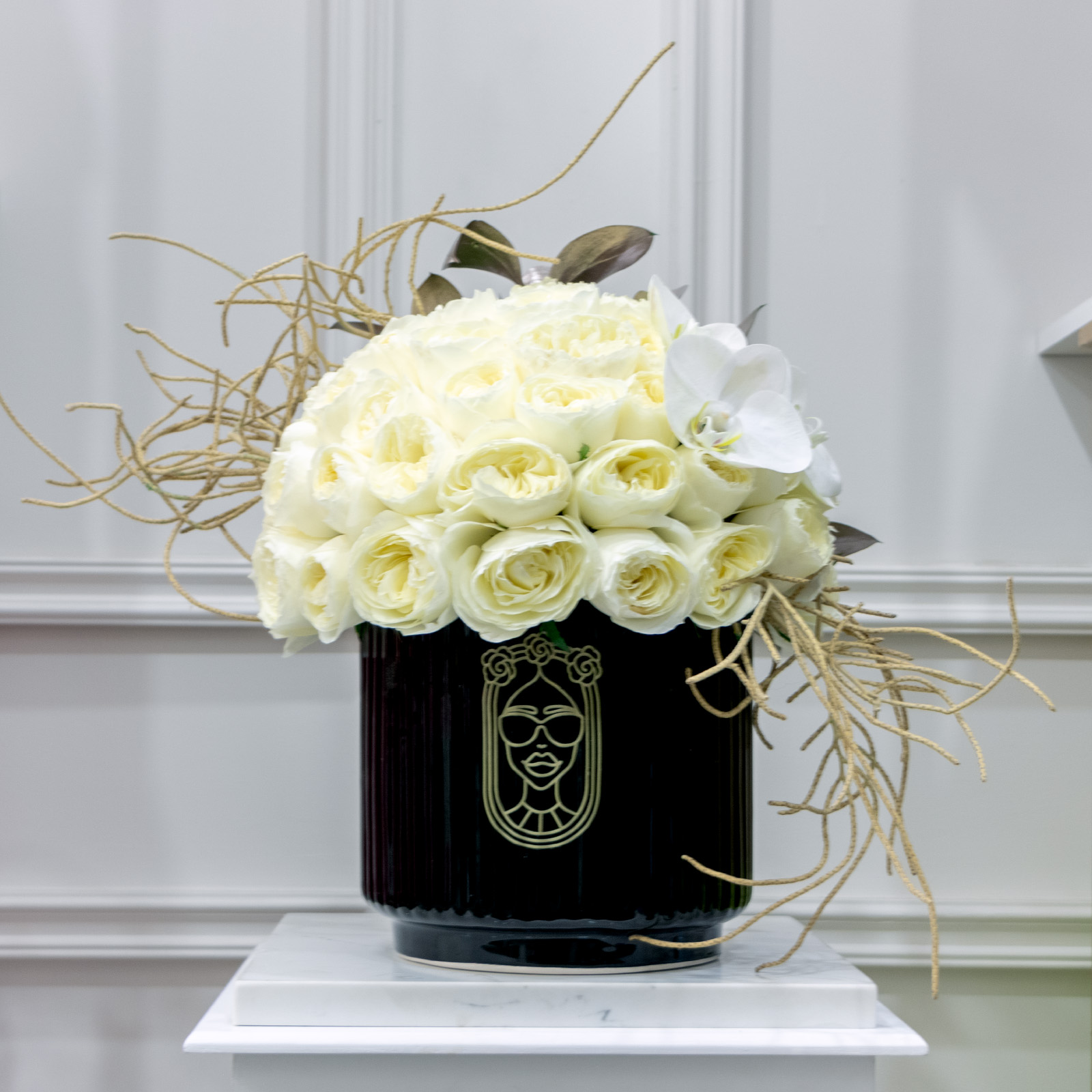 Esfera de 50 rosas inglesas blancas con toques de maruchan y 3 orquideas phalaenopsis blancas sobre base reayada de ceramica negra