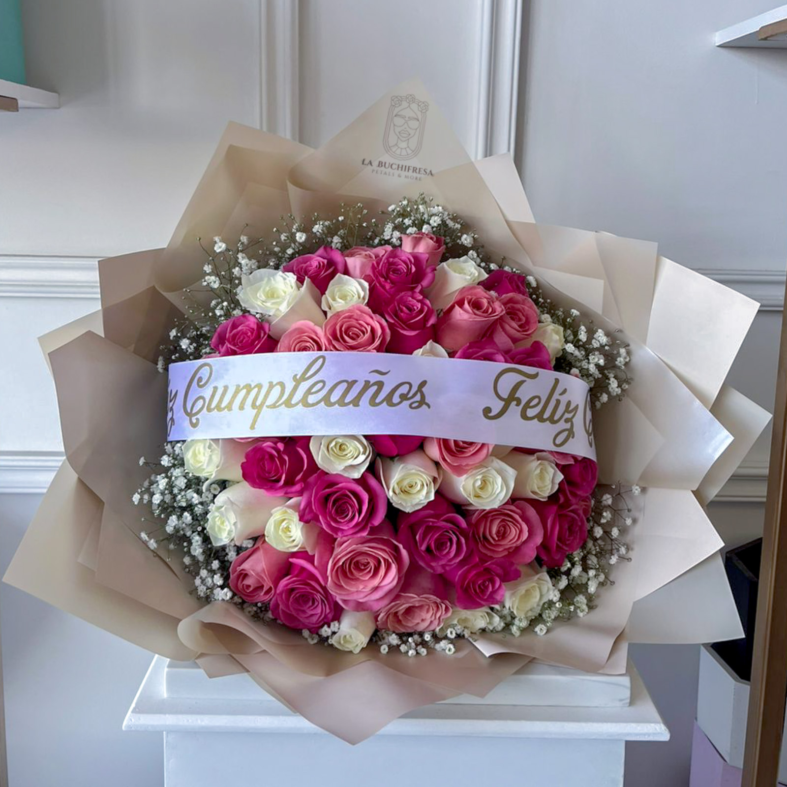 Ramo de 50 rosas rosadas y blancas premium con gypso alrededor y liston de "feliz cumpleaños" envuelto en papel coreano y liston