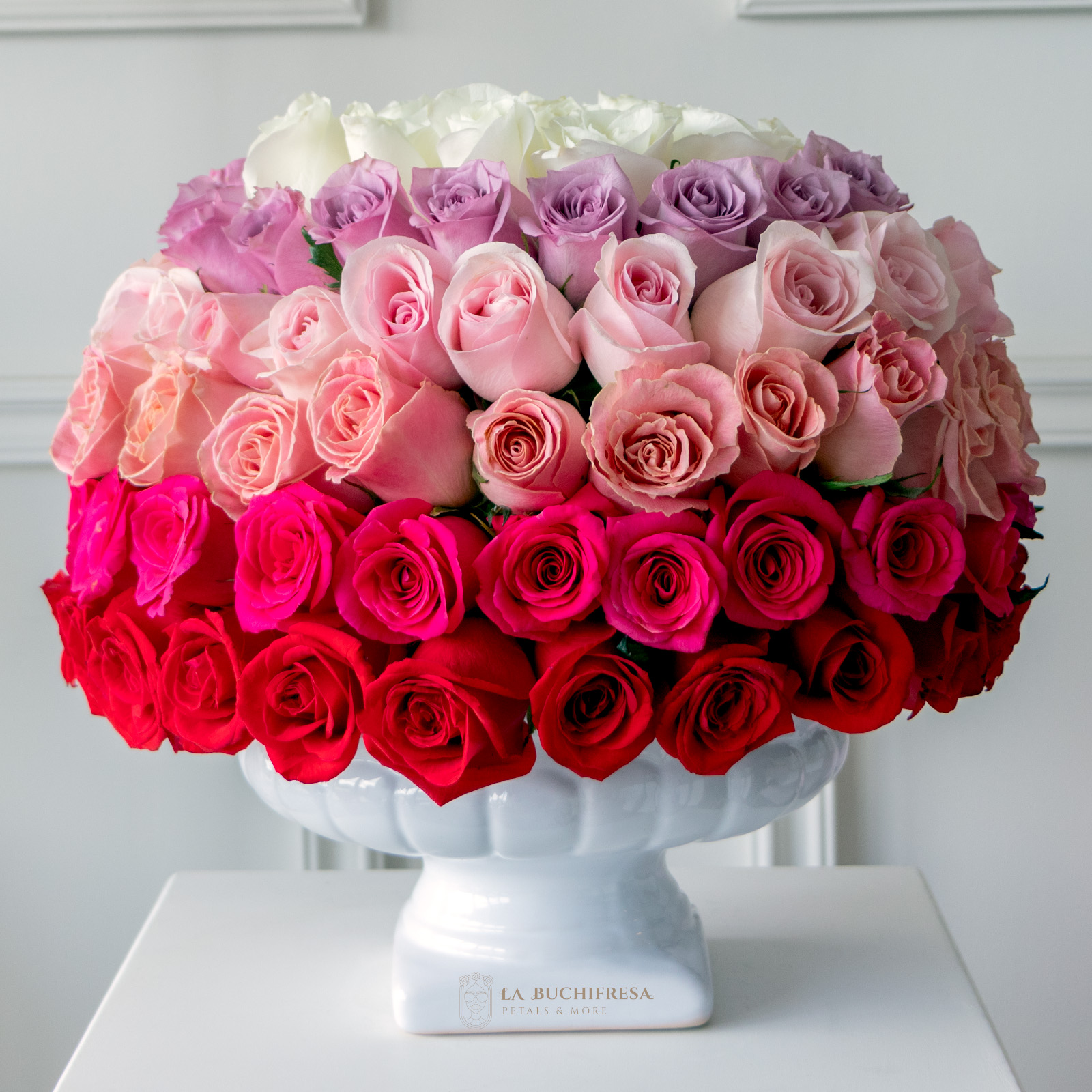 Esfera de 100 rosas premium de color arcoiris sobre copa de ceramica blanca
