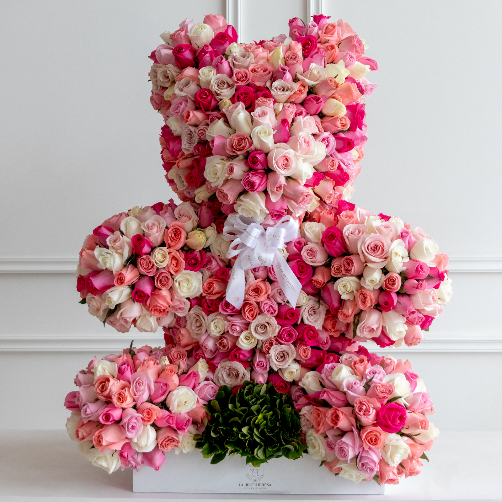 Escultura en forma de oso con 800 rosas rositas premium con un moño de liston sobre medium square white box