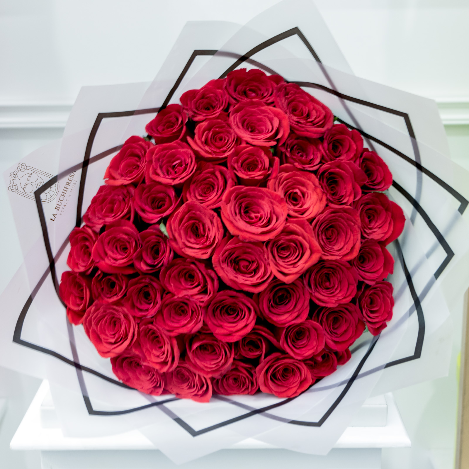 Ramo de 50 rosas rojas premium envuelto en papel coreano y liston