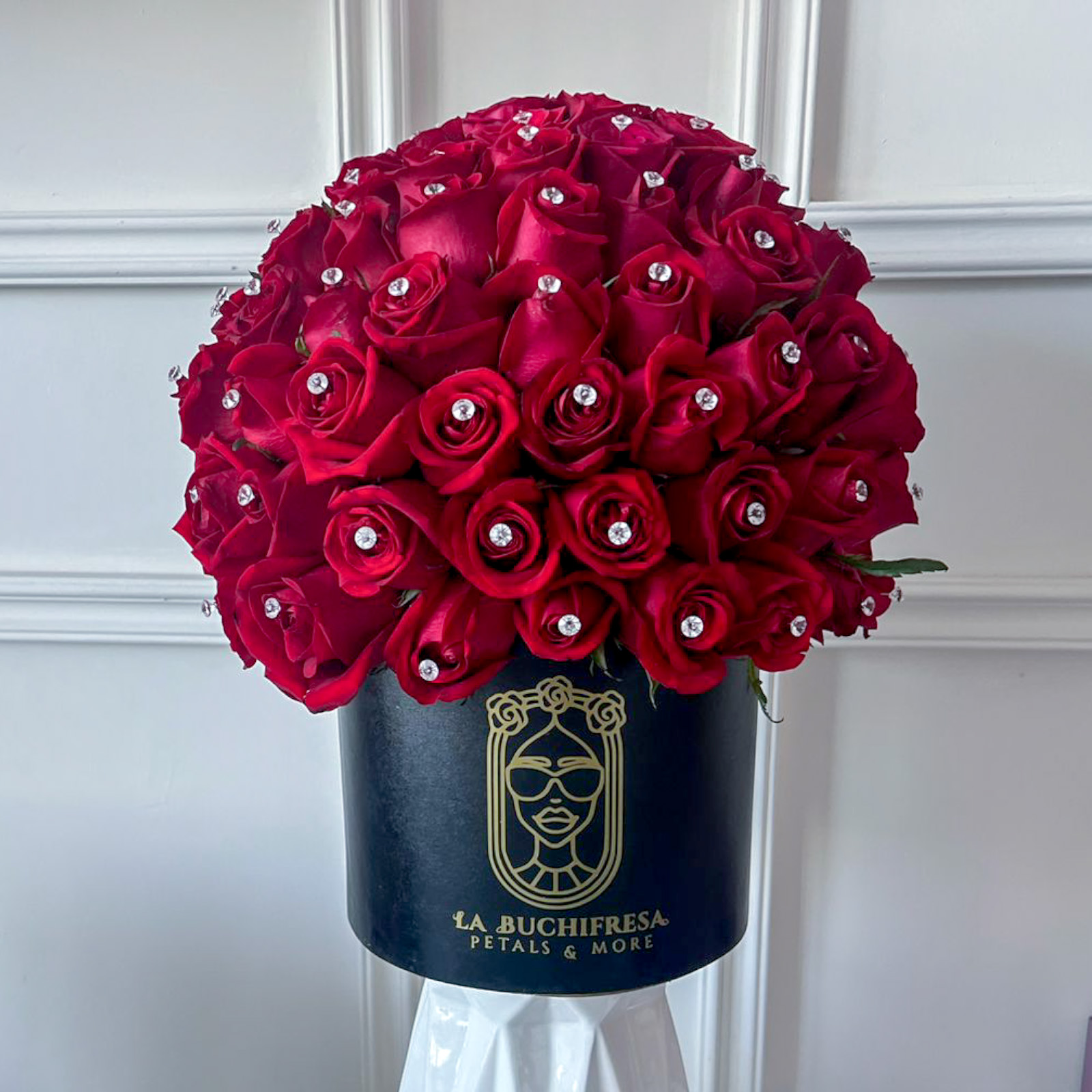 Arreglo de 50 rosas rojas premium con diamantes en las rosas en circular black box