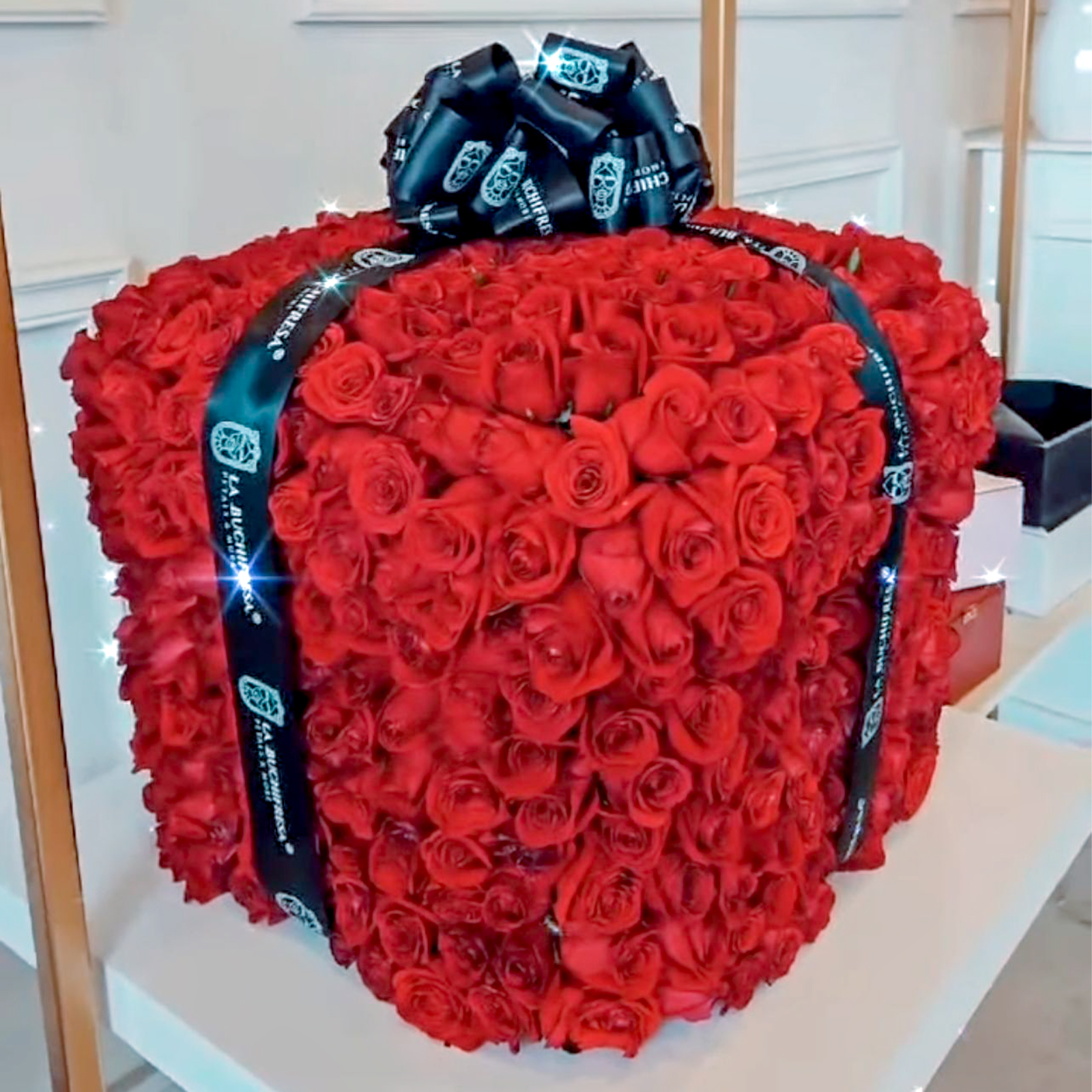 Arreglo de 600 rosas rojas premium en forma de regalo cuadrado envuelto en liston con un moñote