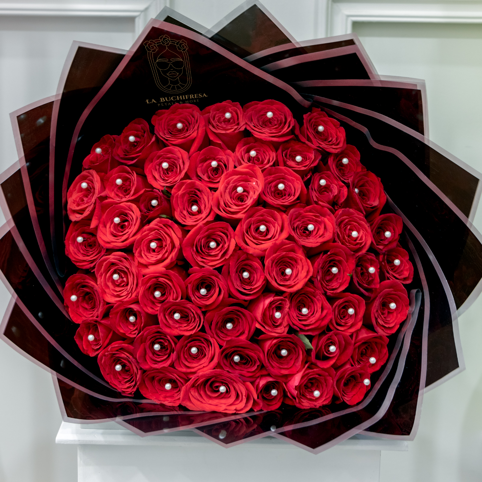 Ramo de 50 rosas rojas premium con perlas en cada rosa envuelto en papel coreano y liston