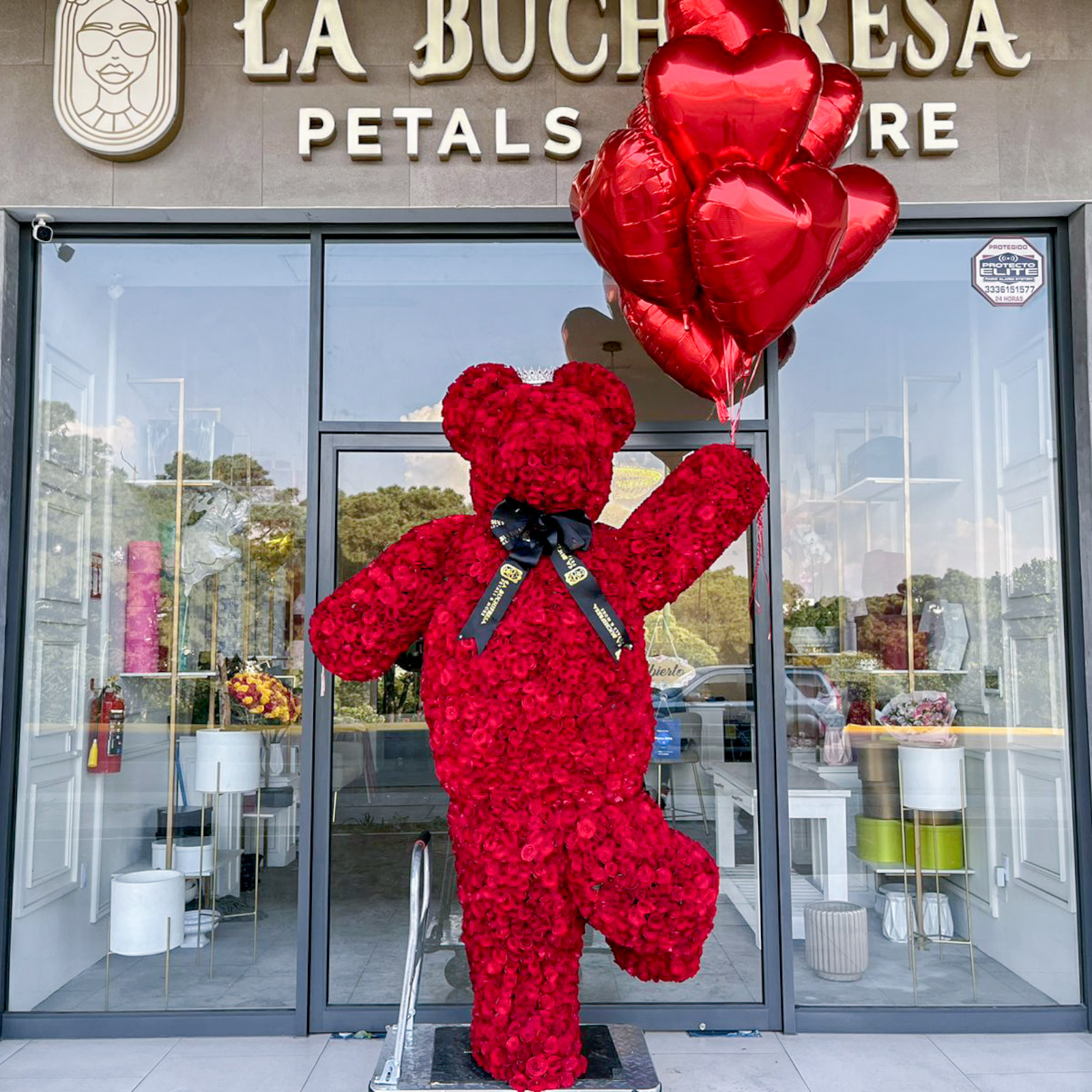 Escultura de 4000 rosas rojas en forma de oso parado en un solo pie sosteniendo 10 globos gigantes en forma de corazon (mide 3 metros de alto aprox)