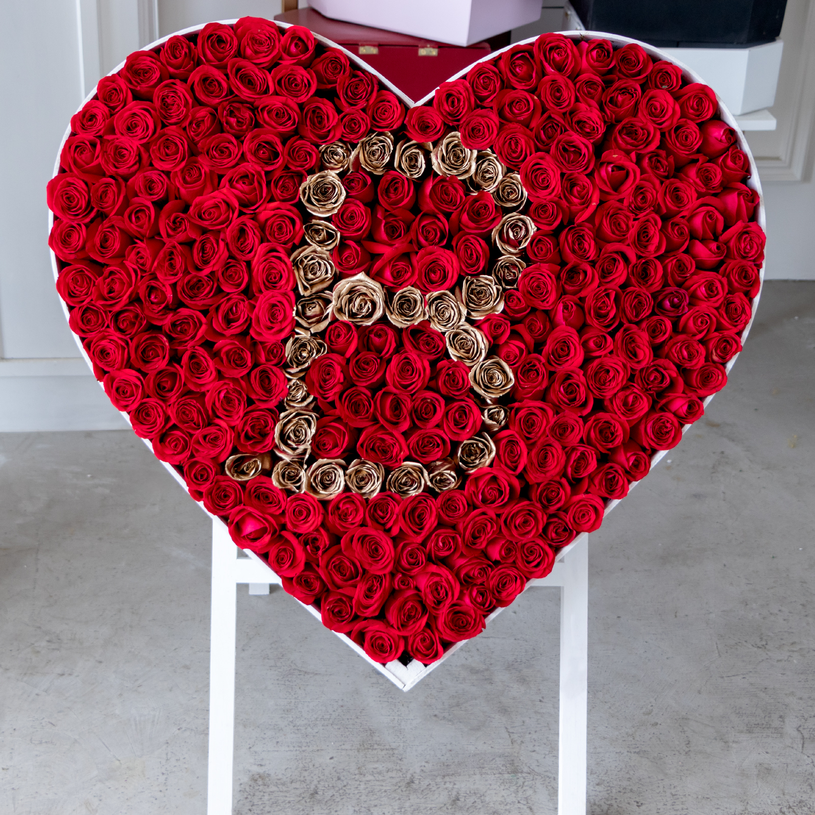 Arreglo de 300 rosas rojas y doradas premium con una letra en el centro en caja de corazon blanca con tripie (FAVOR DE PONER EN NOTAS DEL PEDIDO LA LETRA QUE VAYA A ESTAR EN EL CENTRO)