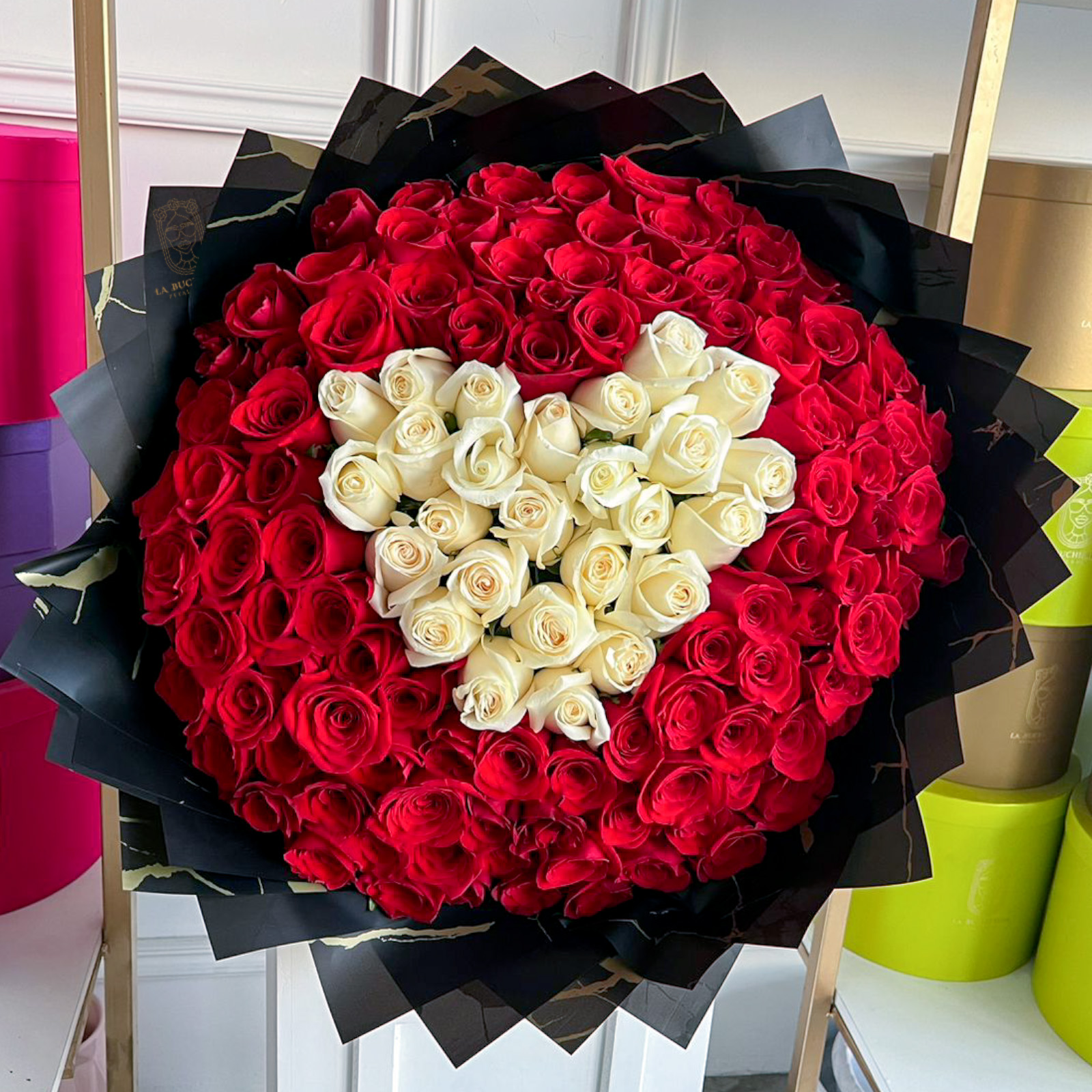 Ramo de 150 rosas rojas premium con un corazon de rosas blancas premium en el centro envuelto en papel coreano y liston