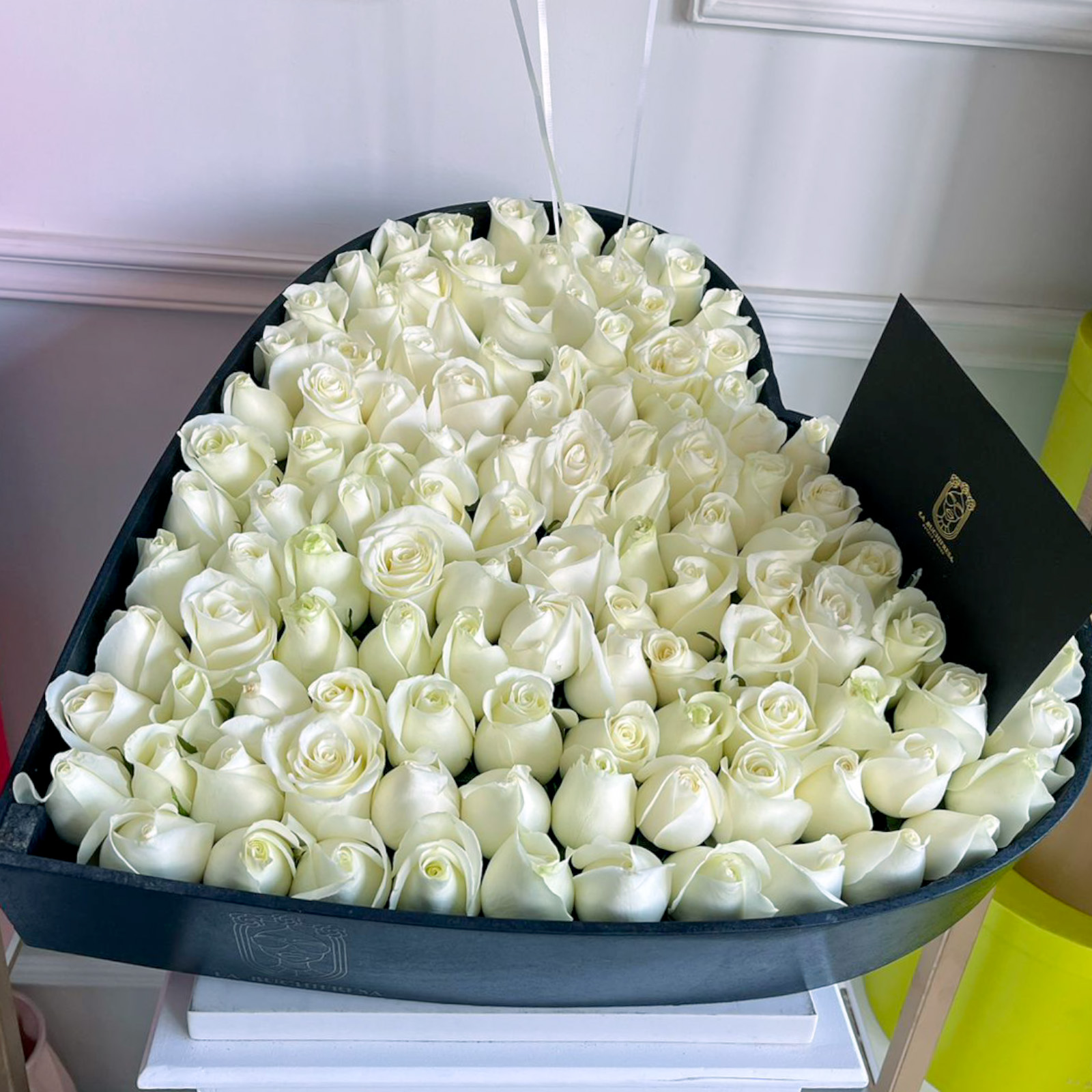Arreglo de 75 rosas blancas premium en caja negra con forma de corazon