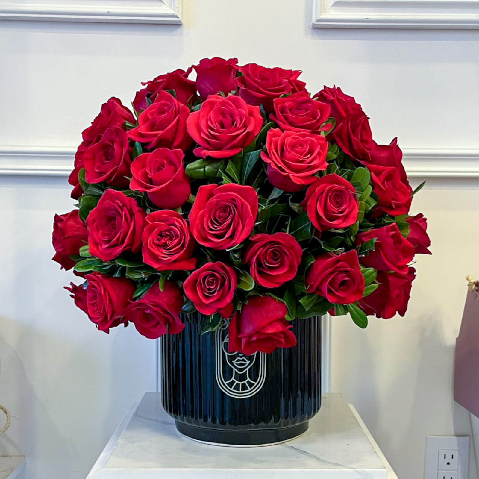 Esfera de 75 rosas rojas premium con clavo japones sobre base de ceramica negra rayada