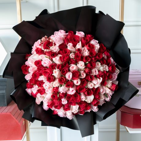 Ramo de 150 rosas rojas y rositas premium envuelto en papel coreano y listón con una corona encima