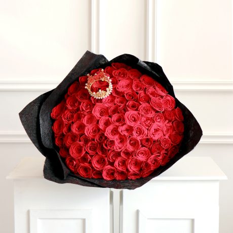 ramo de 100 rosas rojas premium envuelto en papel coreano y liston con una coronita