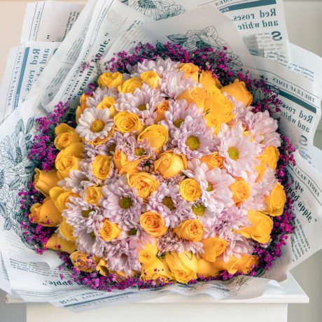 Ramo de 50 rosas amarillas con crisantemo rosa y gypso fucsia alrededor envuelto en papel coreano y liston