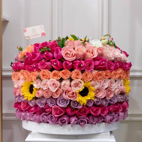 Arreglo de 600 rosas tonos pastel y girasoles con toques de ruscus e imperico y perlas alrededor