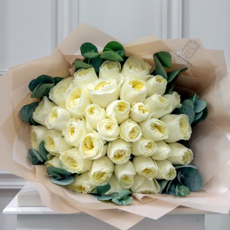 Ramo de 35 rosas inglesas blancas con mini dolar envuelto en papel coreano y liston