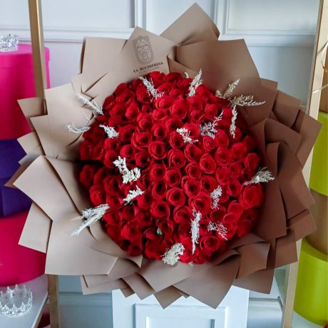 Ramo de 100 rosas rojas con toques de follaje pintado preservado envuelto en papel coreano y liston