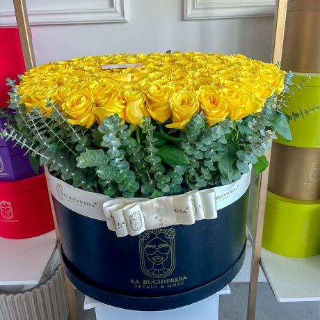 Arreglo de 200 rosas amarillas premium con toques de dolar alrededor en cqja circular negra con liston alrededor